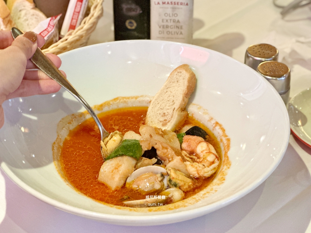 Zuppa di Pesce魚湯用湯勺舀起淡菜蛤蜊